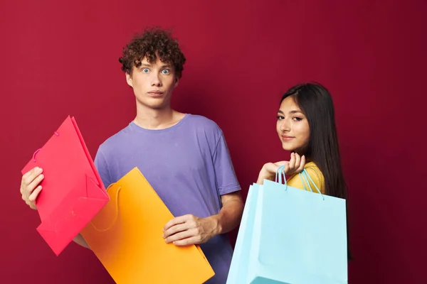Portrait d'un homme et d'une femme en T-shirts colorés avec sacs Shopping Lifestyle inchangé — Photo