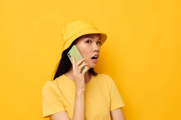 Donna in un cappello giallo e T-shirt parlando al telefono Colpo monocromatico — Foto Stock