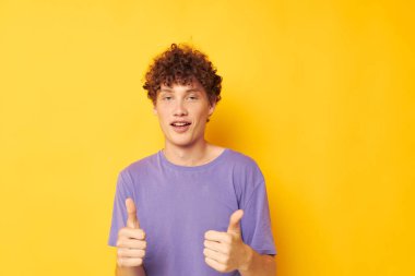 Kırmızı saçlı, kıvırcık saçlı, mor tişörtlü adam duygularına hakim oluyor.