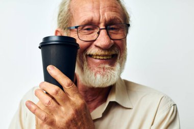 smiling man holding a glass of coffee on a light background