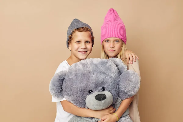 Little boy and girl in hats with a teddy bear friendship Lifestyle unaltered — 图库照片