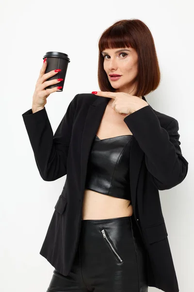 Beautiful woman black jacket drink glass posing light background — Stockfoto