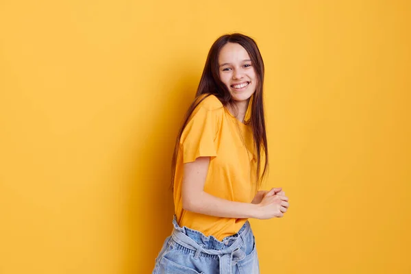 Приваблива жінка в жовтій футболці емоції літнього стилю жовтий фон — стокове фото