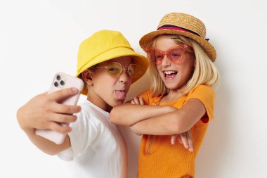 Komik çocuklar telefon modayla selfie çekiyorlar.
