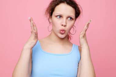 Güzel bir kadın, yakın çekim duygularını kırıştırıyor. Küpeler, yaşam tarzını değiştirmeden poz veriyor.