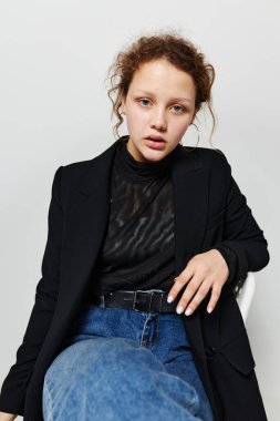 Neşeli kadın siyah ceket pantolonu açık arka plan pozu veriyor.