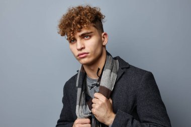 Ceketli tuhaf bir adam. Kareli bir eşarp. Yaşam tarzı değişmemiş.