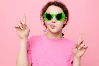 Pembe tişörtlü genç kadın yeşil gözlüklü gençlik modası izole edilmiş arka plan
