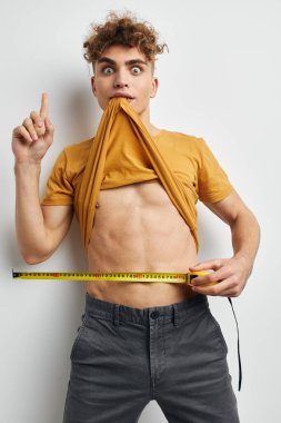 guy with curly hair measuring tape posing