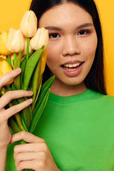 노란색 배경에 변함 이 없는 노란색 꽃들 이 꽃다발을 이룬 여성그린 티셔츠 — 스톡 사진
