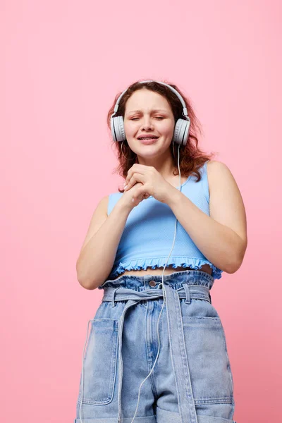 Όμορφη γυναίκα φορώντας ακουστικά απόσπαση της προσοχής μόδας χορό ροζ φόντο αμετάβλητη — Φωτογραφία Αρχείου