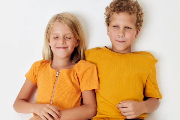 Engraçado crianças menino e menina em amarelo t-shirts estúdio luz fundo — Fotografia de Stock