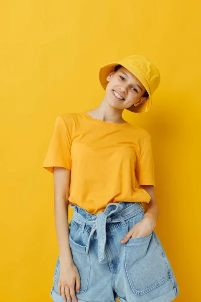 Mujer joven en un sombrero amarillo estilo juvenil ropa casual aislado fondo — Foto de Stock