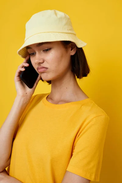 写真かわいい女の子黄色tシャツと帽子夏スタイルとともに電話ライフスタイル変更なし — ストック写真
