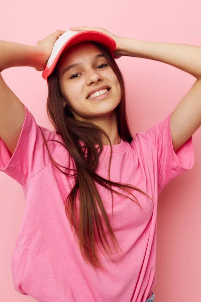Joyeuse jeune fille avec une casquette sur la tête dans un t-shirt rose — Photo