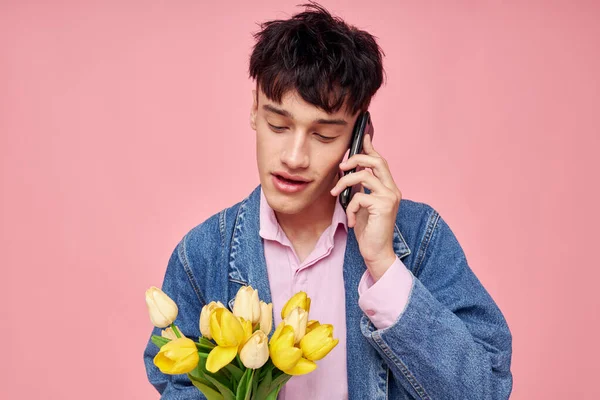 Chico joven con un ramo de flores hablando en el regalo de fecha de teléfono — Foto de Stock