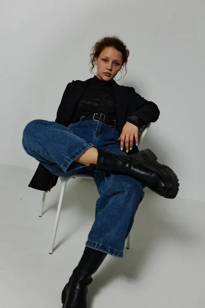 Красива жінка сидить на стільці в чорній куртці моди позує стиль життя незмінним — стокове фото