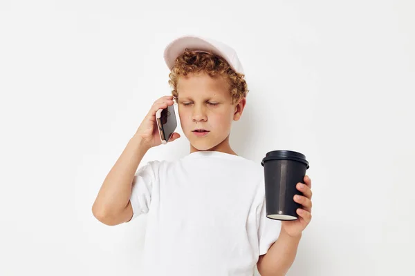 Lindo niño hablando por teléfono con un fondo de luz de vidrio negro inalterado — Foto de Stock