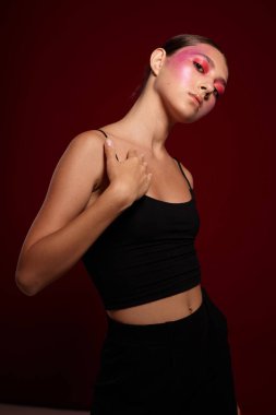 Seksi esmer kadın, el hareketleriyle lüks kozmetik ürünleri yapıyor.