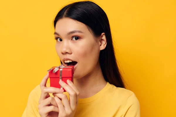 Woman with Asian appearance Little red gift box fun yellow background unaltered — 图库照片