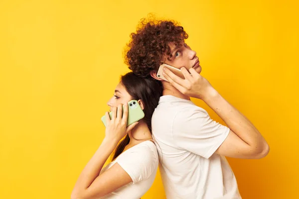 Um cara e uma menina ficar de costas para o outro falando ao telefone — Fotografia de Stock