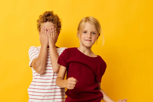 Весёлые дети обнимаются детская мода развлечения желтый фон — стоковое фото