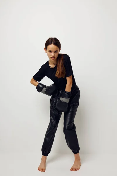 Молода жінка в чорному спорті уніформа бокс рукавички позує стиль життя незмінний — стокове фото