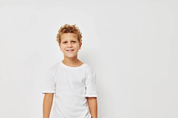 Photo de jeune garçon dans un t-shirt blanc posant l'enfance amusante inaltérée — Photo