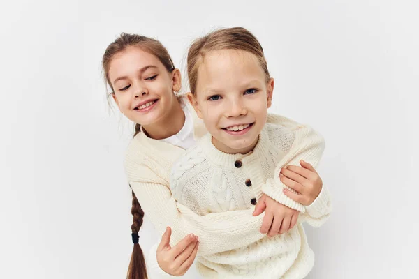 Две маленькие девочки обнимают подругу на светлом фоне — стоковое фото