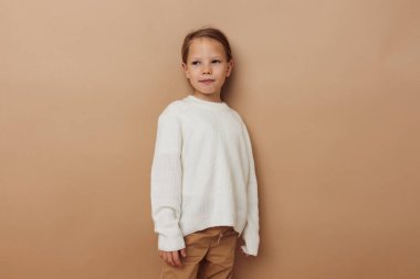 Beyaz süveter giyen güzel genç kız el hareketleriyle çocukluğu değiştiriyor.