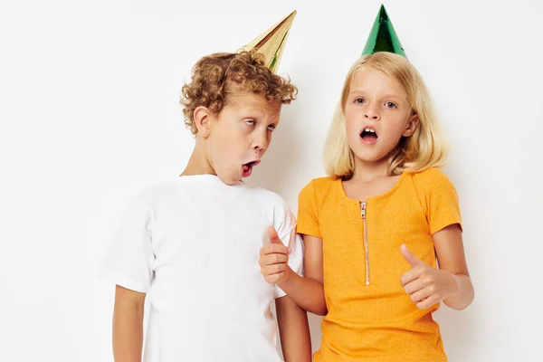 Niños alegres posando emociones vacaciones coloridas gorras aislado fondo inalterado — Foto de Stock