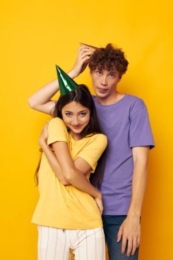 Şapkalı genç çift tişörtleri çok renkli.