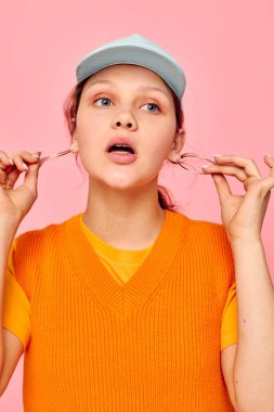 Güzel bir kadın küpe takıyor. Pembe kaplama, değiştirilmemiş.