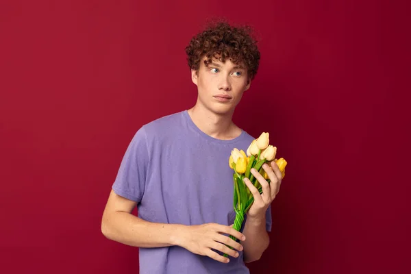 Дивний хлопець тримає жовтий букет квітів фіолетові футболки ізольований фон незмінний — стокове фото