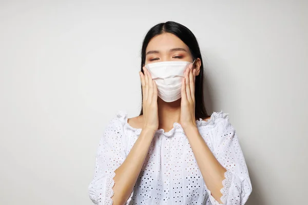 Frau medizinische Maske auf dem Kopfschutz Licht Hintergrund unverändert — Stockfoto