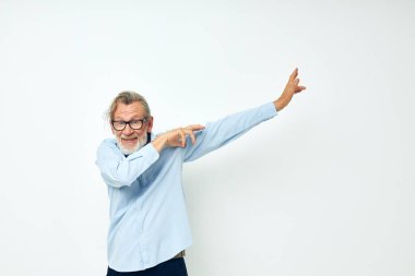 Kıdemli gri saçlı, gömlekli ve gözlüklü adam. Duygularını açığa vuruyor.