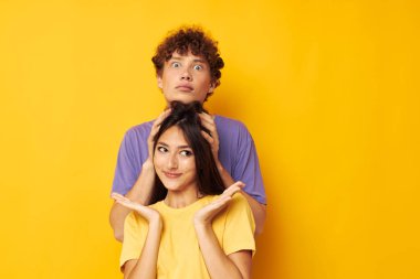 Renkli tişörtler içinde sevimli genç bir çift Arkadaşlık pozu veren eğlenceli yaşam tarzı değiştirilmemiş