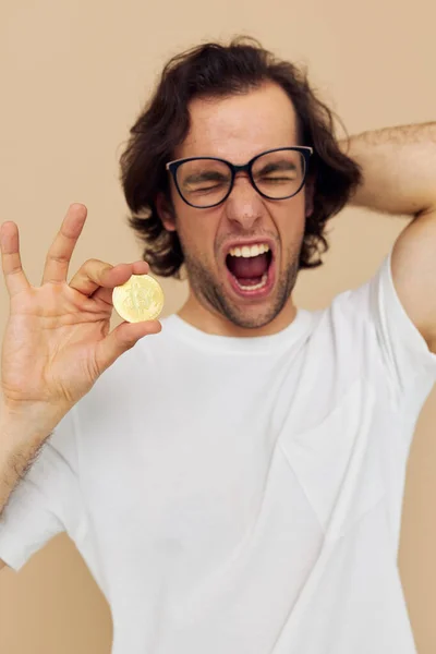 Bel homme avec des lunettes Bitcoin d'or dans les mains fond isolé — Photo