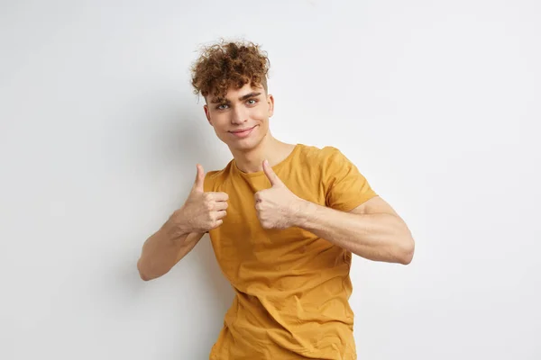 Bel ragazzo in giallo t-shirt gesto mani emozioni isolato sfondo — Foto Stock