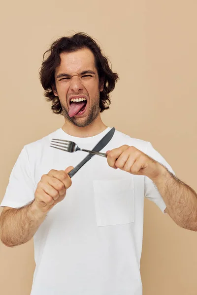 Alegre homem emoções faca e forquilha utensílios de cozinha isolado fundo — Fotografia de Stock