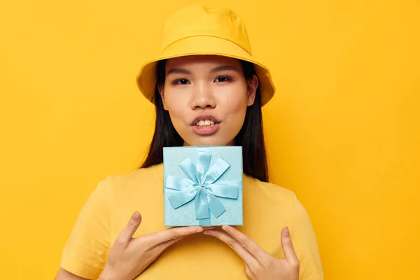 Portrait Asian beautiful young woman in a yellow T-shirt and a hat with a gift isolated background unaltered — 图库照片