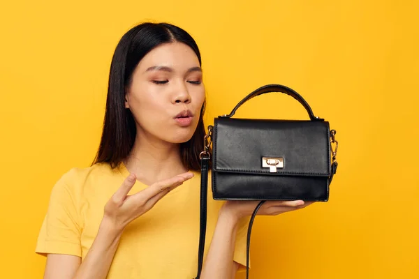Leende asiatisk kvinna handväska mode gul bakgrund — Stockfoto