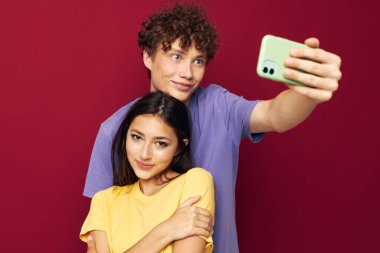 Renkli tişörtleri olan, telefondan izole edilmiş bir geçmişi olan hoş bir adam ve kız.