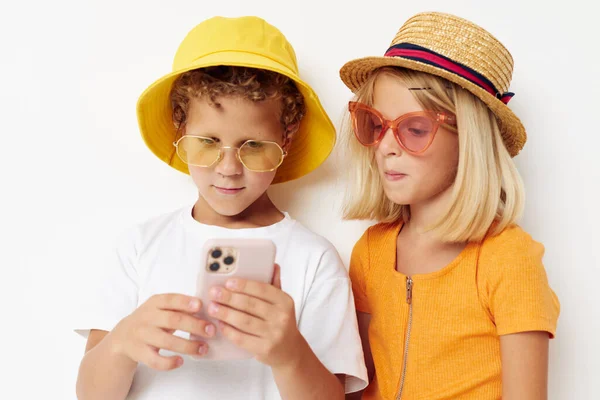 Ragazzo alla moda e ragazza con gli occhiali posa intrattenimento del telefono — Foto Stock