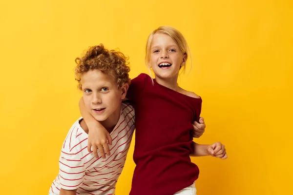 Мальчик и девочка стоят бок о бок, создавая детские эмоции на цветном фоне. — стоковое фото