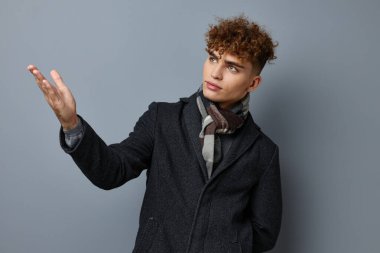 Siyah ceketli çekici bir adam modadan soyutlanmış arka plan.