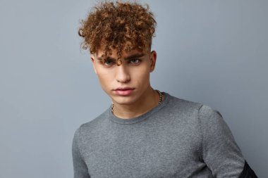 Gri kazaklı çekici bir adam. Moda stüdyosu izole edilmiş.