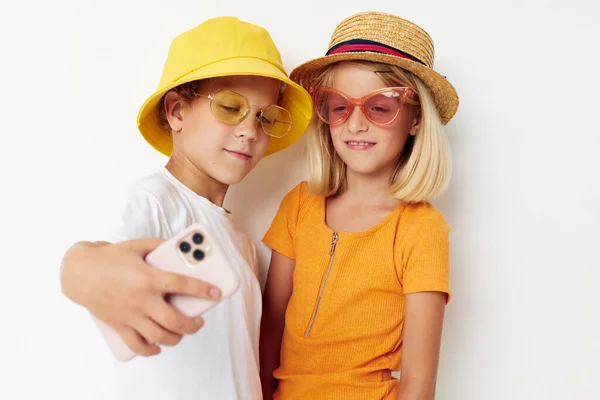 Модний хлопчик і дівчина в окулярах позує на телефон розваги — стокове фото