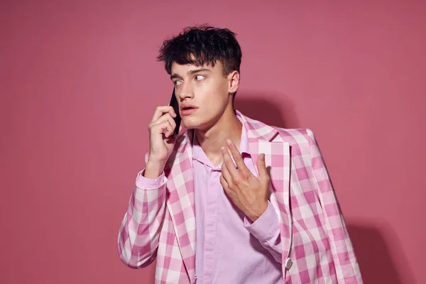 휴대 전화를 들고 있는 예쁜 남자 핑크블라 저 스타일의우아 한 배경을 그대로 간직 한 — 스톡 사진