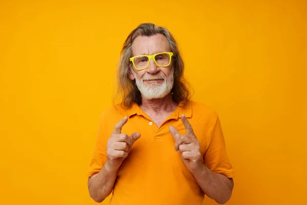 Portrait of happy senior man in yellow glasses with a gray beard emotions cropped view — Photo